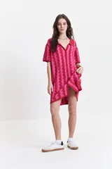 Vestido corto tejido de punto con cuello tipo camisa, botones frontales y diseño a rayas onduladas en tonos azul, verde y blanco.