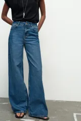 Jeans de tiro medio, color azul denim, con cinco bolsillos, corte wide leg y largo extra.
