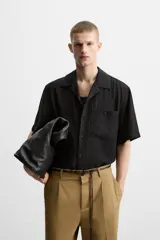Camisa de hombre relaxed fit con cuello bowling y manga corta, confeccionada en tejido fluido con mezcla de viscosa a rayas verticales en tonos verde y blanco.