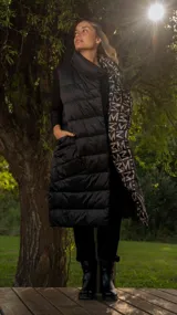 Chaleco negro de nylon, largo con diseño acolchado y bolsillos laterales.
