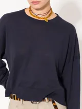 Sweater tejido suave y flojo, color crudo, con cuello redondo y mangas largas.