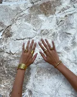 Brazalete ancho de bronce macizo con textura irregular.