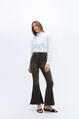 Pantalón jean acampanado color marrón oscuro, de tiro alto y denim con alforza central.