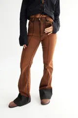 Pantalón jean oxford de tiro alto, color azul oscuro con desgaste en los muslos y rodillas. Presenta alforzas en el delantero y dobladillo en la botamanga.
