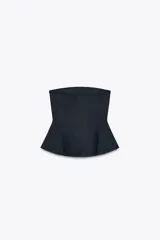 Top negro con escote recto y hombros descubiertos. Tiene hilo metalizado y bajo peplum. Cierre lateral con cremallera oculta.