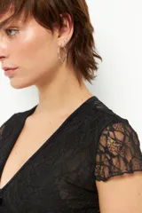 Top de encaje negro con escote en V y mangas cortas, ideal para agregar textura a cualquier outfit.