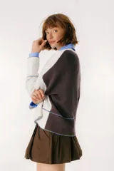 Sweater beige y azul con cuello en V y ribete bordeaux.