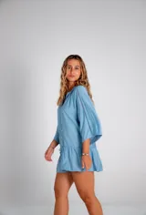 Vestido corto celeste con mangas 3/4 acampanadas y detalle de puntilla en mangas y ruedo.