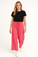 Pantalón ancho de tiro alto, color fucsia vibrante, con cintura elástica y cordón ajustable. El tejido parece ser lino o una mezcla ligera.