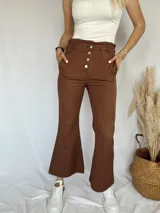 Jean slouchy color marrón, con corte de campana y botones frontales.