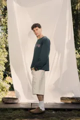 Crewneck (jersey de cuello redondo) unisex color gris oscuro, con estampado frontal que dice "RE:SKIN" y texto pequeño debajo. Presenta mangas largas y corte holgado.