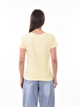 Remera negra de algodón con estampado frontal de la palabra "MERCI" en letras delineadas con colores del arcoíris.