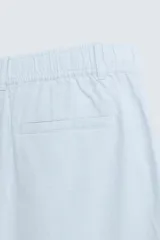 Bermuda azul marino de corte regular, confeccionada en tejido de algodón y lino. Cuenta con bolsillos frontales y traseros, y cierre frontal con cremallera y botón.