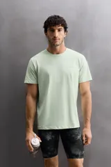 Camiseta deportiva verde claro confeccionada en tejido técnico, ligero y elástico en cuatro direcciones. Tiene cuello redondo, manga corta, zonas con estructura perforada y logo estampado.