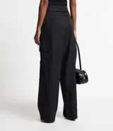 Pantalón de vestir negro, de corte recto, con bolsillos cargo laterales, cintura lisa y pliegues delanteros.