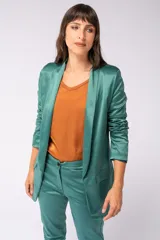 Blazer verde de satén elastizado con corte entallado, terminaciones pulidas, bolsillos funcionales y cierre frontal con botón.