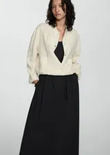 Falda larga blanca con corte amplio y plisados delicados, diseñada para una apariencia elegante.