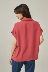 Blusa color salmón de viscosa, corte holgado, con cuello camisero y mangas cortas con dobladillo.
