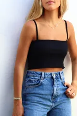 Top blanco de corte cropped, con tirantes delgados y diseño acanalado.