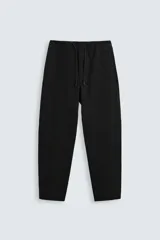 Pantalón negro de corte carrot fit, confeccionado en tejido de algodón. Cuenta con cintura elástica ajustable con cordón, bolsillos frontales y un bolsillo trasero de plastrón.