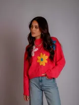 Sweater tejido color rosa con cuello redondo y bordados de flores de colores.