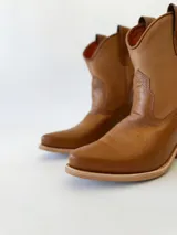 Botas texanas de cuero color camel con diseño clásico y punta estilizada.