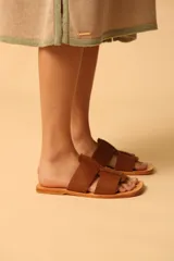 Sandalias plateadas con tiras anchas entrecruzadas y suela plana color camel.