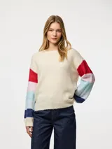 Sweater de punto color crema con cuello redondo y mangas largas con rayas horizontales en colores rojo, celeste, azul y rosa.