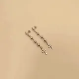 Par de caravanas colgantes de plata 925 con cierre de mariposa. Cada una presenta una medalla redonda, tres bolitas y una cruz.