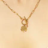 Cadena dorada de acero quirúrgico con eslabones tipo clip y dije de trébol de cuatro hojas.