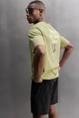 Remera verde oliva de corte relaxed fit, cuello redondo y manga corta. Tiene un pequeño logo estampado en el bajo.