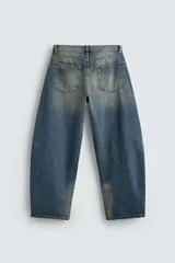 Pantalón de jean celeste con efecto lavado, corte amplio tipo balloon fit, tiro medio, cinco bolsillos y cierre frontal con cremallera y botón.