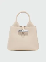 Bolso Longchamp modelo Le Roseau XS, color beige, con doble asa corta y correa larga extraíble.