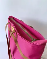 Bolso de lona color negro con detalles en cuero marrón, con bolsillo interno y forro de tela.
