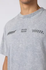 Remera gris con efecto lavado, cuello redondo y estampado con motivos de automovilismo.