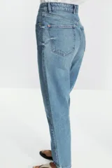 Pantalón de jean negro de corte recto, tiro alto y largo tobillero.