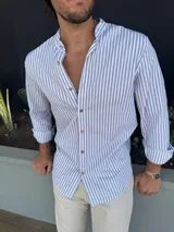 Camisa de manga larga con cuello mao y rayas verticales grises y blancas.