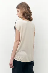 Blusa beige con estampado geométrico, cuello redondo y mangas cortas.