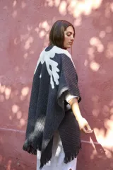 Ruana color negro confeccionada con técnica de fieltro agujado, con diseño artístico en tonos claros.