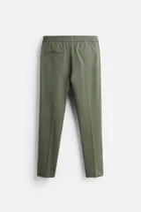 Pantalón color arena de corte recto, confeccionado en tejido elástico. Cuenta con cintura elástica ajustable con cordón, bolsillos laterales y bolsillos de vivo en la parte trasera.