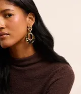 Aros colgantes con forma geométrica irregular, con pieza superior dorada y pieza inferior con diseño marmolado en tonos verdes y marrones.
