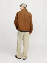 Campera marrón de algodón con cuello clásico, cierre frontal con cremallera y bolsillos laterales.