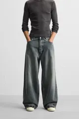 Pantalón de jean negro de corte amplio, con cinco bolsillos, efecto lavado y cierre frontal con cremallera y botón.