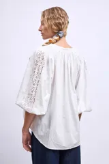 Camisa blanca de mangas 3/4 con detalle de encaje en el frente.