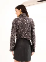 Buzo de punto gris con cuello alto y lentejuelas plateadas.