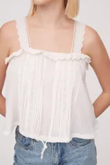 Musculosa color salmón con breteles finos y detalle de puntilla en el escote.