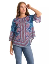 Blusa de gasa con estampado de arabescos y motivos florales en tonos azul marino, rojo y celeste. Presenta cuello redondo y mangas tres cuartos amplias. El bajo es asimétrico, más largo en los laterales.
