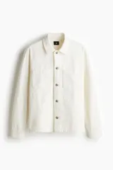 Sobrecamisa color crema en tejido texturizado de algodón, corte estándar, con cuello inglés, tapeta lisa, bolsillos superiores abiertos, canesú en la espalda, mangas largas con puños abotonados y bajo recto.