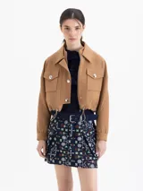 Chaqueta corta color marrón, sin forrar, confeccionada en sarga. Presenta doble cuello (mao interno y camisero externo), doble acceso frontal con cierre y broches, bolsillos plaqué con tapa y jareta con elástico y tancas metálicas. Las mangas tienen recortes y puños con broches.