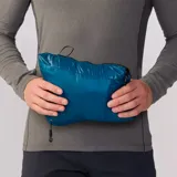 Campera azul con cierre frontal, cuello alto y bolsillo negro en el pecho.